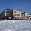 Une école et son stationnement sous la neige.