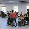 Des élèves handicapés et des intervenants à l'intérieur d'une salle de classe sur l'heure du dîner.