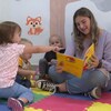 Une éducatrice lit un livre aux enfants.