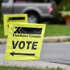 Des affiches d'Élections Canada indiquent la direction de l'entrée d'un bureau de vote.