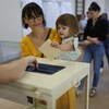 Une fillette dépose le bulletin de vote de sa mère dans un bureau de scrutin de Strasbourg.