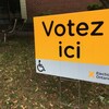 Photo d'une affiche jaune qui dit: Votez ici.
