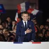 Main sur le cœur, Emmanuel Macron sourit devant ses partisans.