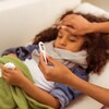 Un adulte prend la température d'un enfant malade faisant de la fièvre en raison de la grippe ou d'un rhume.
