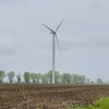Une éolienne à Massueville dans un champ agricole un jour de pluie.