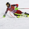 Un skieur qui contourne une porte à toute vitesse lors d'une épreuve de slalom géant.