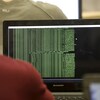 Un étudiant observe des lignes de code sur un écran d'ordinateur alors qu'il participe à un cours de défense informatique.