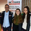 Des étudiants, membres de la brigade, sourient, devant une pancarte arborant le logo du service. 
