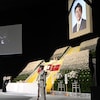 Une photo de Shinzo Abe lors de ses funérailles nationales sous de nombreuses fleurs.