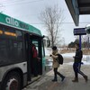 Des personnes montent à bord d'un autobus.