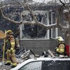 Des pompiers sur les lieux de l'explosion d'une maison. 