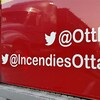 Un camion de pompiers sur lequel on peut lire le nom d'utilisateur Twitter du Service des incendies d'Ottawa : « @IncendiesOttawa ».