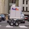 Un robot qui roule dans les rues d'une ville. 