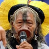 Une leader autochtone s'adressant au sénat brésilien à l'aide d'un micro.