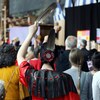 Une femme de dos tient une plume d'aigle pendant la cérémonie de fermeture de l'Enquête nationale sur les femmes et les filles disparues et assassinées.