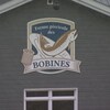 La pancarte de la ferme piscicole des Bobines sur la bâtisse extérieure.