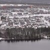 Gros plan de la ville de Fermont, où on voit des dizaines de maisons, le mur de Fermont et un lac.