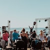 Un musicien salue le public qui l'acclame. Le concert a lieu en plein air, face à la mer. 