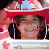 Une fillette qui a un drapeau du Canada peint sur une joue.