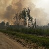 La route 33 près de Swan Hill, avec un feu de forêt et une fumée épaisse, en Alberta, le 21 mai 2023.