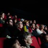 Des gens sont assis dans une salle de cinéma. 