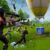 Capture d'écran du jeu vidéo Fortnite, où on voit plusieurs personnages armés converger vers une montgolfière.