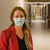 France Desrosiers dans le corridor d'un hôpital portant un masque.