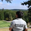 Une femme vêtue à l'effigie de la police environnementale regarde un terrain de golf.