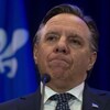 Gros plan de François Legault, qui se mord les lèvres. 