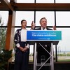 François Legault est derrière un lutrin, il a les mains levées. Geneviève Guilbault se trouve derrière lui à sa droite.