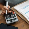 Des factures et une calculatrice sur une table.