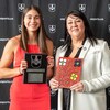 Frédérique Chiasson montre sa plaque honorifique en souriant. Elle pose avec une dignitaire.