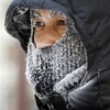 Le visage d'un homme couvert d'un capuchon et un foulard gelé.