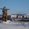 Un inukshuk devant des maisons enneigées en janvier 2023.