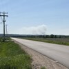 Une route déserte et de la fumée au loin.