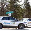 Deux véhicules de la G R C sont stationnés près d'une intersection pour bloquer une route.
