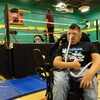 Gabriel pose devant le ring avec une grimace de lutteur et un pouce dans les airs.