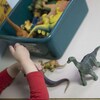 Un enfant s'amuse avec des figurines de dinosaures.