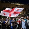 Des centaines de manifestants sont rassemblés, certaines personnes brandissant le drapeau géorgien, d'autres, le drapeau européen.