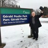 Gérald Poulin devant l'affiche du parc qui porte son nom.