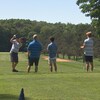 Quatre hommes de dos sur un terrain de golf