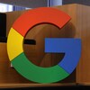 Une sculpture du logo de Google est fixée sur un bureau en bois.
