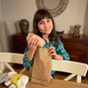 Grace Kennedy, 9 ans, tient un sandwich qu'elle va insérer dans un sac brun. 