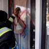 Un homme efface une croix gammée rouge peinte sur une porte.