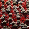 De nombreux agents de la Gendarmerie royale du Canada (GRC) sont debout en uniforme rouge lors d'une cérémonie.