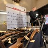 Une table avec des armes est installée près du podium où un policier s'adresse aux médias, au quartier général de la GRC à Winnipeg, le 5 décembre 2022. 