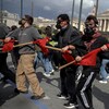 Des hommes équipés de masques à gaz et armés de bâtons marchent dans les rues d'Athènes, en Grèce.