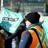 Des manifestants agitent des drapeaux qui portent la mention « Nous, d'une seule voix ».