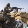 Un combattant yéménite tire avec son arme durant un accrochage avec les rebelles houthis près de la ville de Marib, en juin 2021.