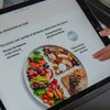 Une femme consulte le guide alimentaire sur une tablette.